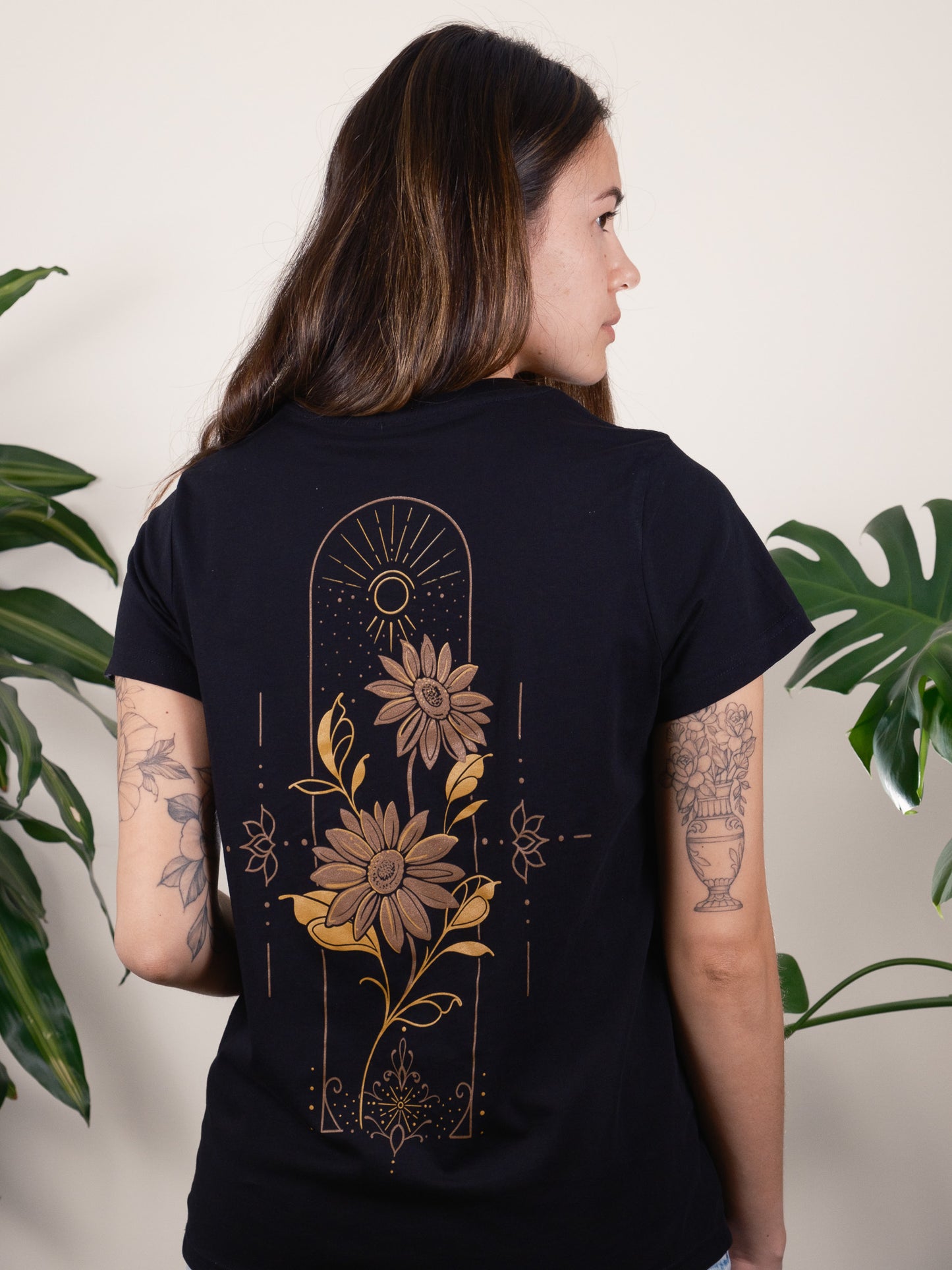 Back of T-shirt Featuring Golden Sunflowers Encased in a Geometric and Dot-work Frame. Female Model 2