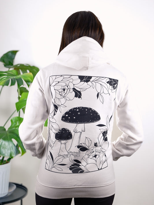 Female model back view wearing Somatic Blossoms hoodie, displaying floral and fine line tattoo-inspired artwork