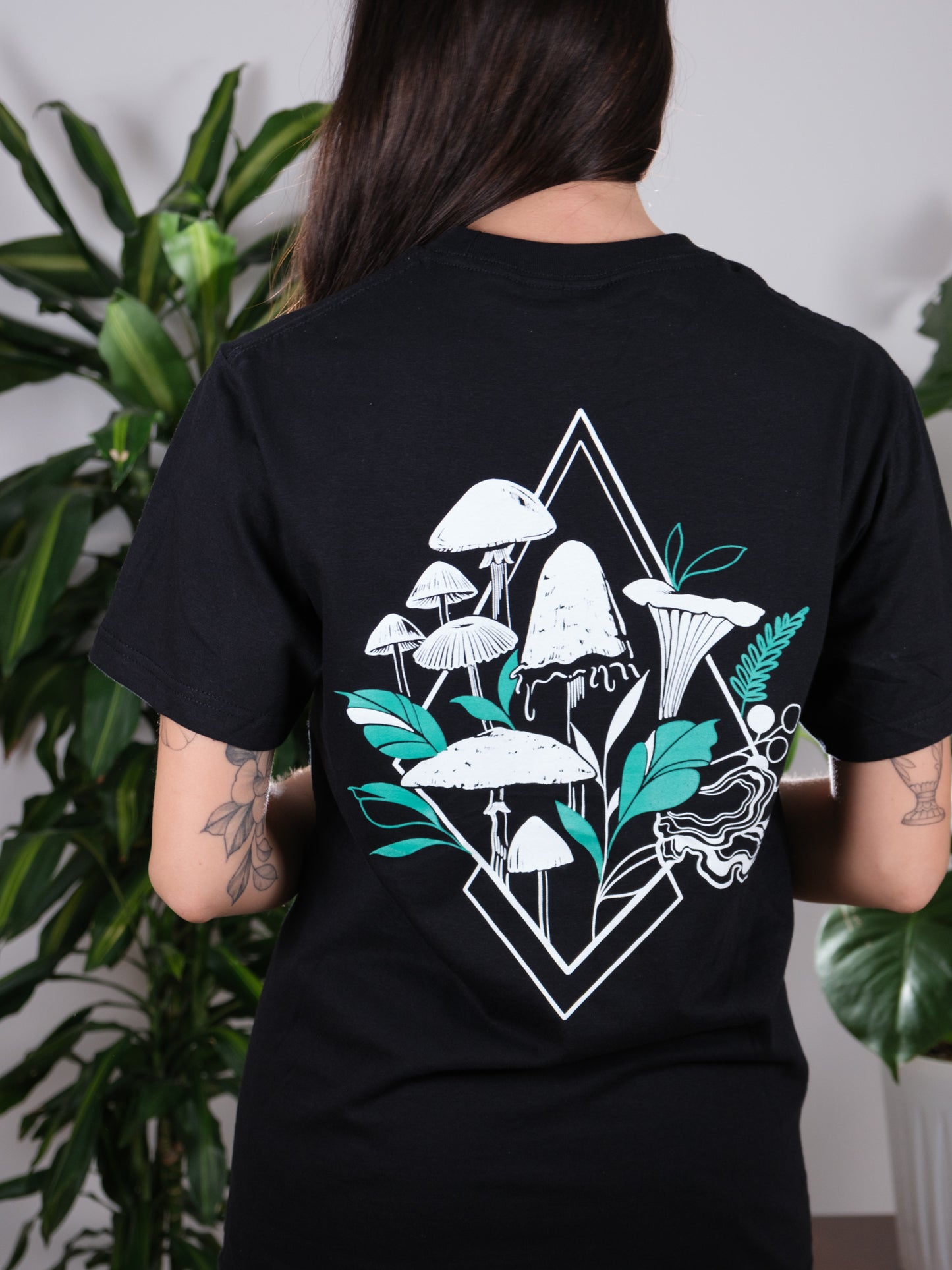 Female model displaying the back of the Fragrance of Fall Tee, highlighting the intricate mushroom design.