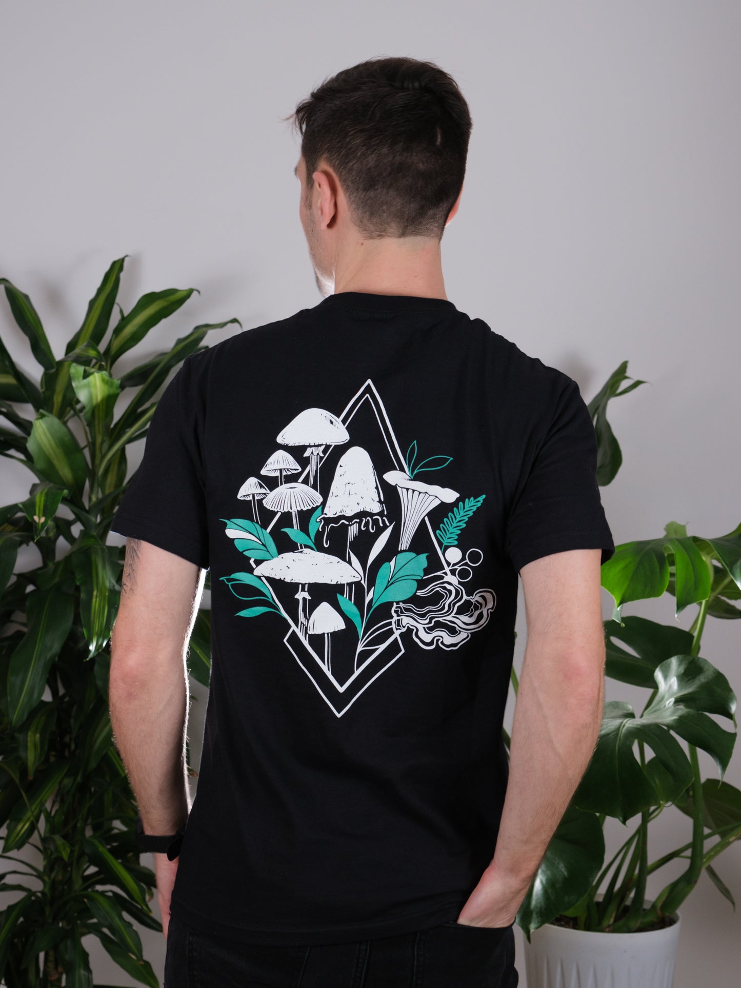 Back view of the Fragrance of Fall Tee on a male model, featuring tattoo-inspired geometric mushroom art.