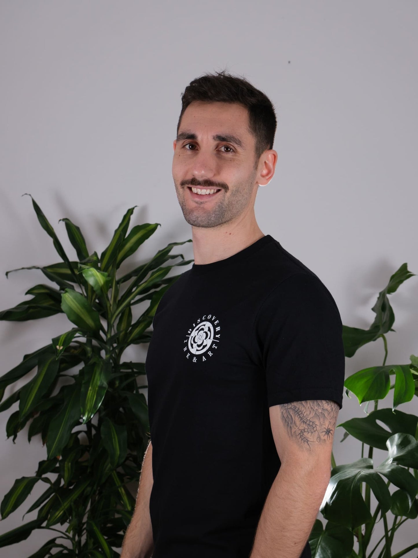 Front view of the Love Knows No Bounds Black Tee worn by a male model, showcasing its stylish and casual design.