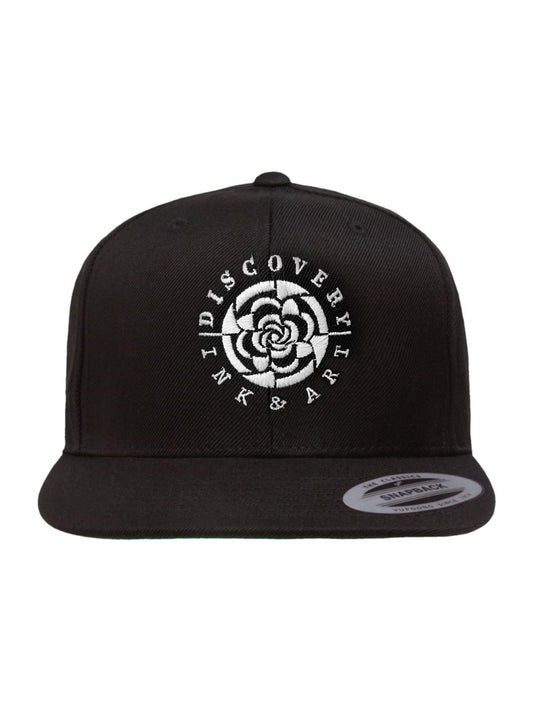Black snapback hat with the words Discovery Ink & Art circled around a mandala-inspired logo