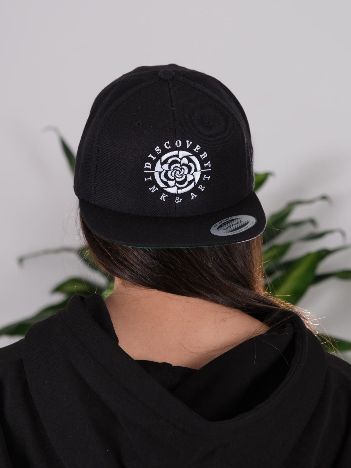 Back view of the Discovery Ink & Art Rising Snapback hat, highlighting the adjustable strap for a comfortable fit.