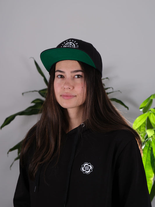 Front view of the Discovery Ink & Art Rising Snapback hat, featuring a unique mandala and floral-inspired design.