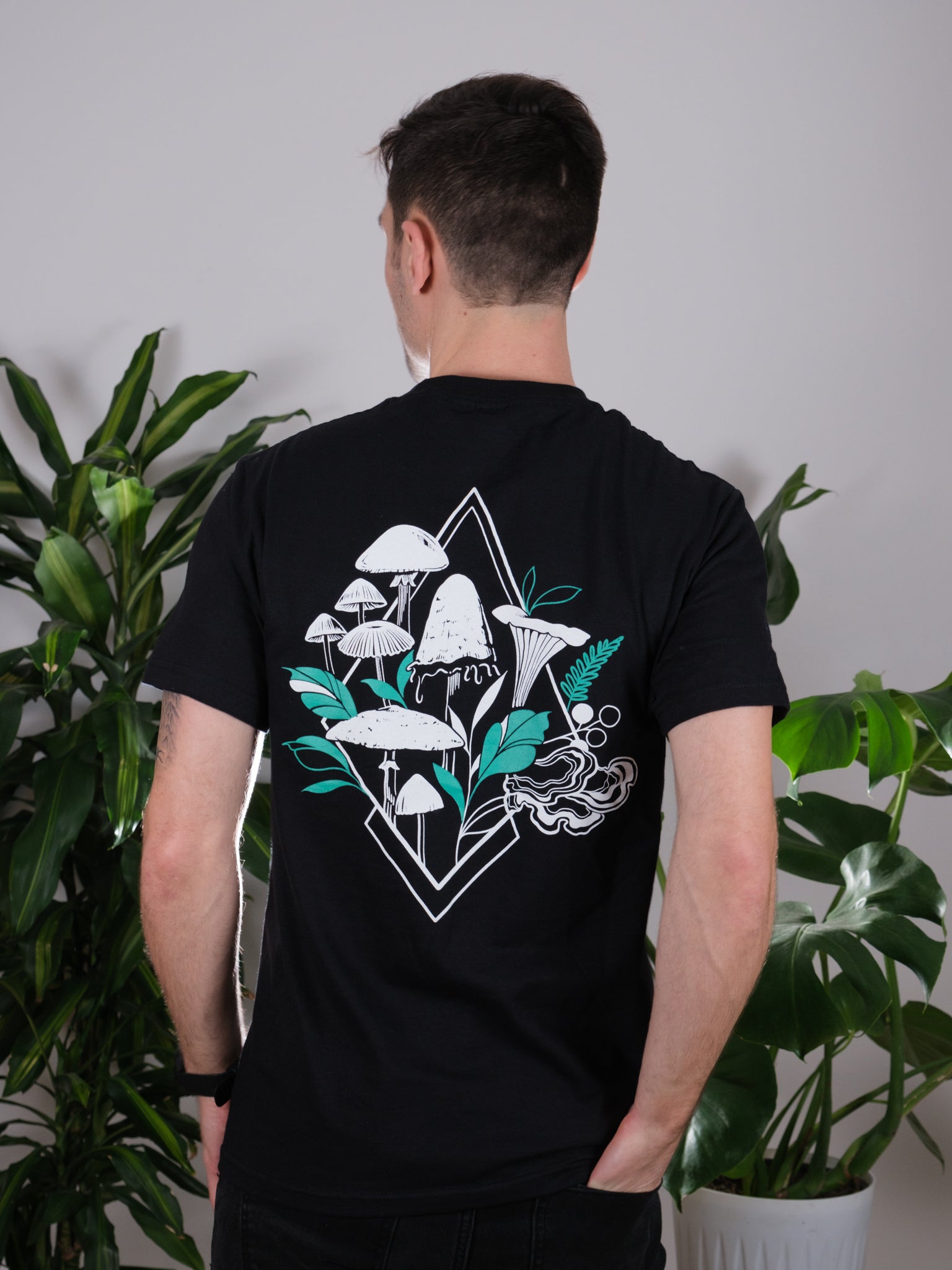 Back view of the Fragrance of Fall Tee on a male model, featuring tattoo-inspired geometric mushroom art.