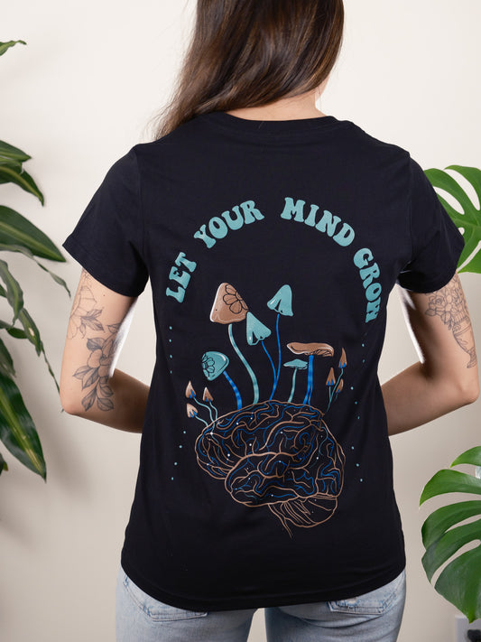 Female model displaying the back of the Let Your Mind Grow Tee, highlighting the intricate mushrooms growing out of a brain. 